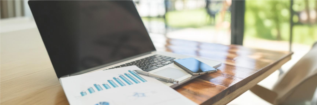 Notebook sobre a mesa com um gráfico de analises sobre o teclado, representando a automação contábil